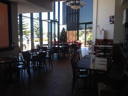a dining room with tables and chairs and a christmas tree at The Central Hotel Motel Lakes Entrance in Lakes Entrance
