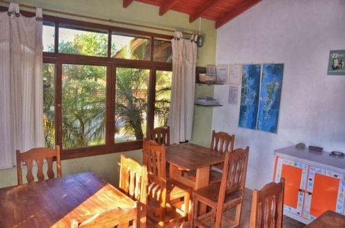 a dining room with a wooden table and chairs at SunHouse Praia do Rosa in Praia do Rosa