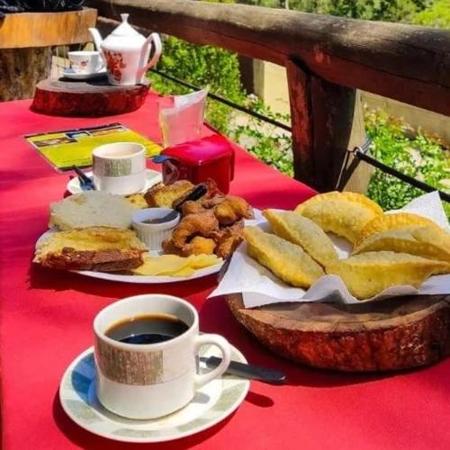 a table with a plate of food and a cup of coffee at Jd Container Graciosa in Quatro Barras