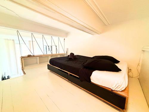 une chambre avec un lit dans une pièce blanche dans l'établissement Cosy appart 4pers vieux Nice, à Nice