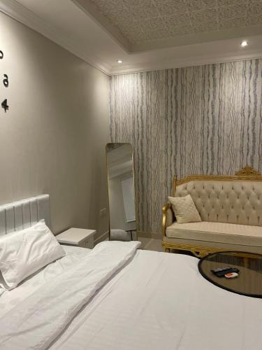 a bedroom with a bed and a couch and a mirror at قرطبه مودرن - قريبة من المطار in Riyadh