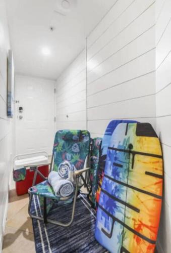 a room with a chair and a surfboard in it at Breezy Does It Royal Palms 404 DIRECT GULF FRONT in Gulf Shores