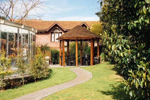 a garden with a gazebo in front of a house at Destinar Apart in Carilo