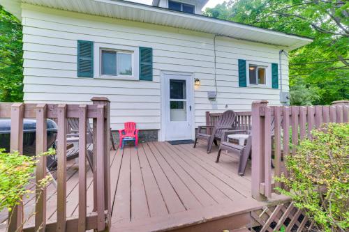 a wooden deck with chairs and a house at Walk to Lake Michigan Pet-Friendly Charlevoix Gem in Charlevoix