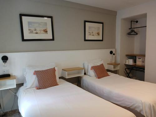 two beds in a hotel room with white sheets at San Marco Hotel Curacao & Casino in Willemstad