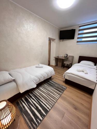 a hotel room with two beds and a television at Kovač Residence in Zrenjanin
