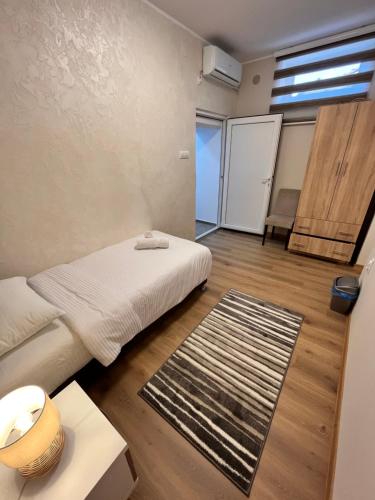 a small room with a bed and a rug at Kovač Residence in Zrenjanin