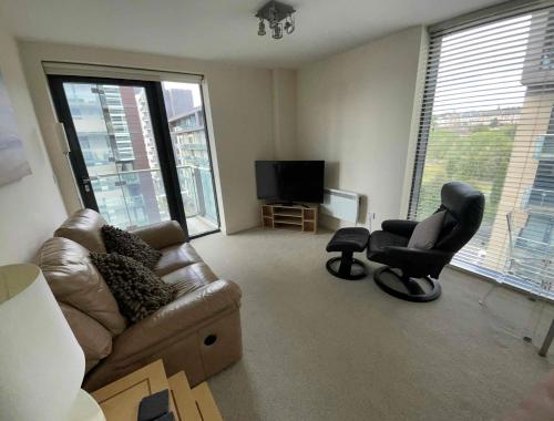 a living room with a couch and two chairs and a television at Glasgow Harbour River West End in Glasgow