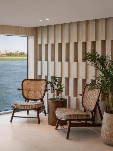 two chairs and a table in a room with water at Soleil Nile Cruise - Every Monday from Luxor for 4 & 7 Nights, and every Friday from Aswan for 3 & 7 Nights in Luxor