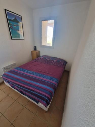 - une petite chambre avec un lit et une couverture rayée dans l'établissement Quiet T2 with pool near beach and port, à La Londe-les-Maures