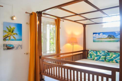 a room with a crib and a window at Sands Beach Villa Flic en Flac in Flic-en-Flac