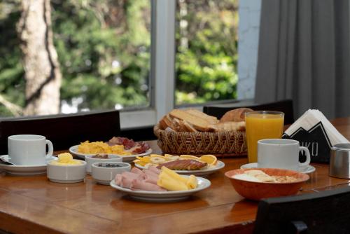 Una mesa cubierta con platos de comida y bebidas. en HOTEL DINKO, en San Carlos de Bariloche
