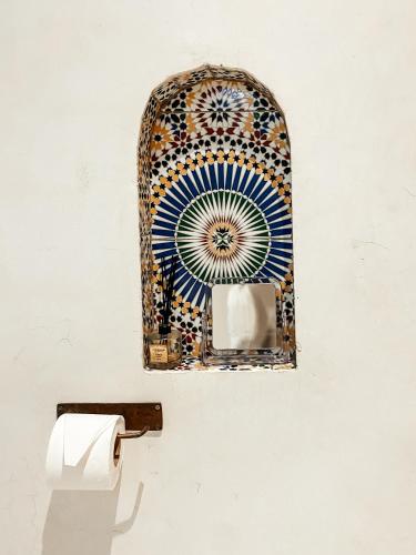 a bathroom with a toilet paper dispenser on a wall at Riad Al Manara in Essaouira