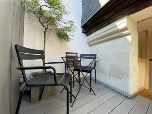 une rangée de chaises et de tables sur un balcon dans l'établissement Superbe studio avec terrasse - Cathédrale, à Nantes