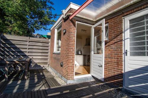 a brick house with a white door and a porch at Centre Hilversum, 20 minutes train to Amsterdam in Hilversum