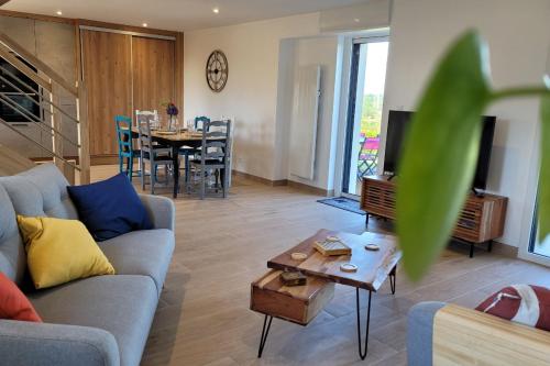 プルーアにあるMaison vue exceptionnelle mer sur les falaises de Plouha, Côtes d'Armorのソファとテーブルのあるリビングルーム