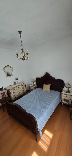 a bedroom with a bed and a chandelier at Casa do Neto Tiago in Fundão