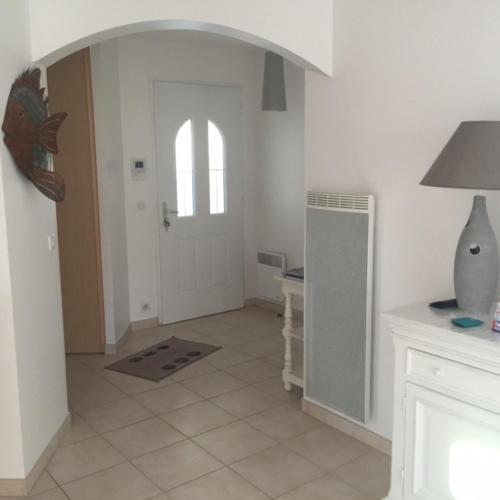 une chambre blanche avec une porte et une chambre avec une table dans l'établissement VILLA Meschers sur Gironde, à Meschers-sur-Gironde