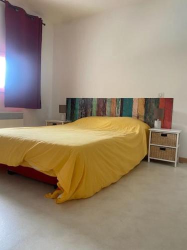 une chambre avec un lit avec une couverture jaune dans l'établissement VILLA Meschers sur Gironde, à Meschers-sur-Gironde