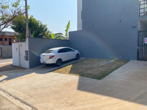 ein weißes Auto, das neben einem weißen Gebäude parkt in der Unterkunft Studio próximo à Unicamp Limeira in Limeira