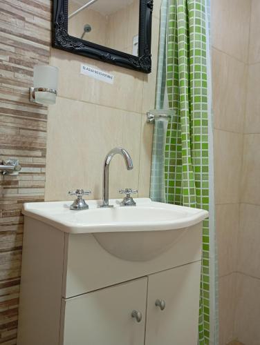 a bathroom with a sink and a green shower curtain at Los Poin 2 in Mar de Cobo