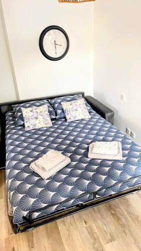 Ce lit se trouve dans un dortoir doté d'une horloge murale. dans l'établissement Studio cosy - 2 pers - Béziers - Centre - Terrasse - Clim, à Béziers