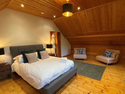 a bedroom with a large bed in a room with wooden ceilings at Enlighten Lodge Great Ayton Yorkshire in Great Ayton