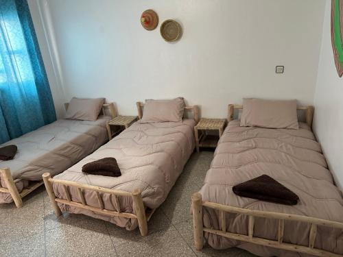 a room with three beds in a room at Sea Surf and Sun in Tamraght Ouzdar
