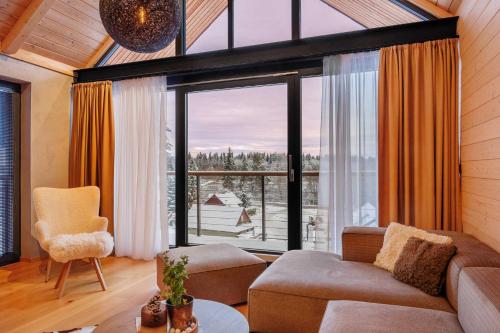 a living room with a couch and a large window at TRI VODY Demänovská Dolina in Liptovský Mikuláš