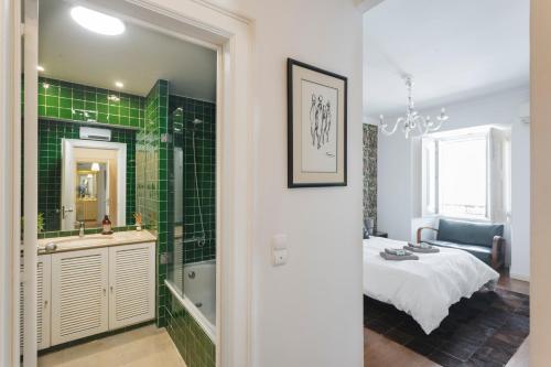 a bedroom with a green tiled shower and a bed at Chiado Prestige View Apartment in Lisbon
