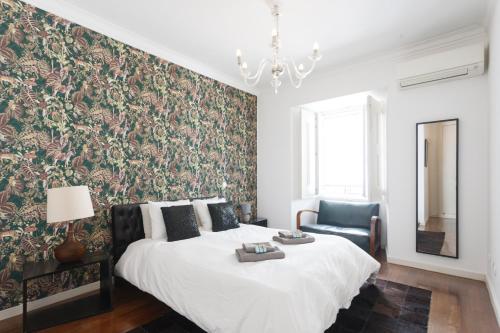 a bedroom with a large bed with a floral wallpaper at Chiado Prestige View Apartment in Lisbon