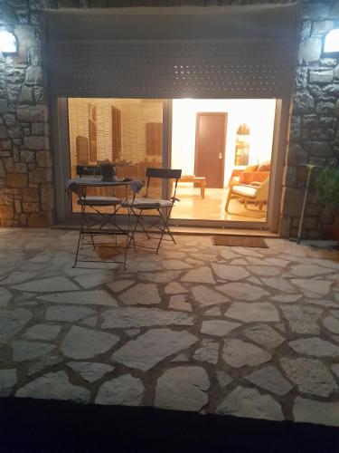 a room with a table and chairs on a stone floor at Studio Persa in Tseréni