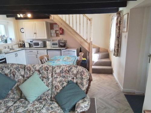 un salon avec un canapé et un escalier dans l'établissement Dairy Cottage Newcastle Emlyn, à Newcastle Emlyn