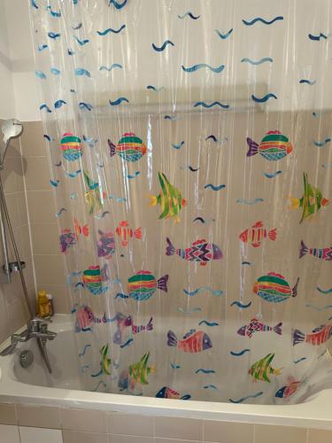 - un rideau de douche avec du poisson dans la baignoire dans l'établissement Hermoso apartamento a 10 minutos De la Torre Eiffel, à Paris