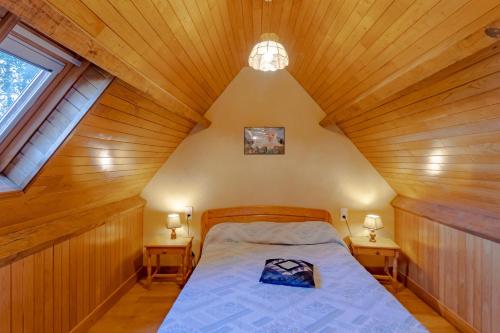 ein Schlafzimmer mit einem Bett in einer Holzdecke in der Unterkunft Le Grand Pech in Le Sirey