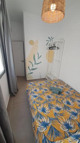a bedroom with a bed with a blue and yellow blanket at The Wave Temple II in Las Palmas de Gran Canaria