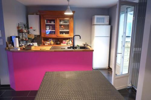 - une cuisine avec un comptoir rose et un réfrigérateur dans l'établissement Ma maison pour Vous !!, à La Haie