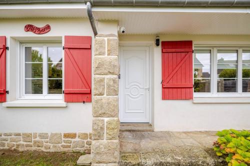 a house with red shutters and a door at Charmante maison avec piscine in Beaussais sur Mer