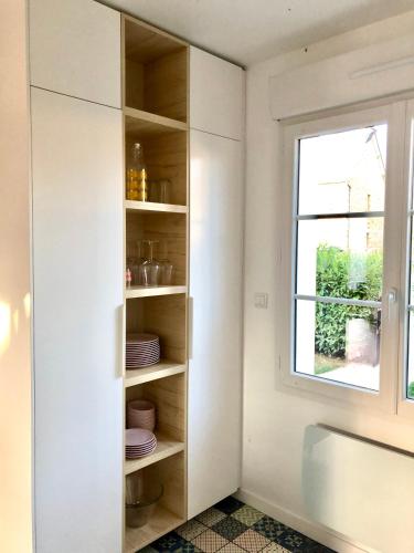 a kitchen with white cabinets and a window at Charmante maison avec piscine in Beaussais sur Mer