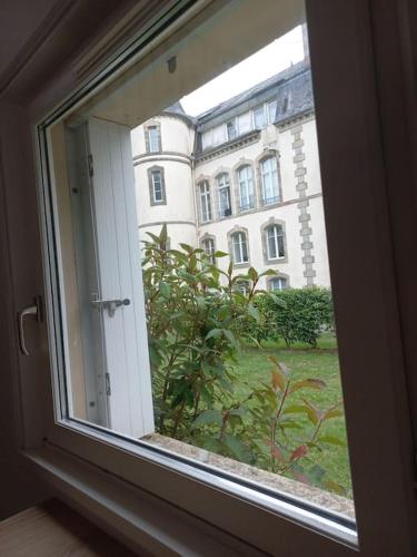 a window with a view of a building at jolie maison au château in Audierne