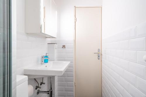 a white bathroom with a sink and a shower at Panoramic App A06-6 in Sierksdorf