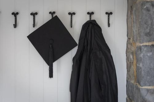 a black cape and an umbrella hanging on a wall at The Old School House - A Superb Newly Converted Barn with Hot Tub Sleeping 8 guests in Carmarthen