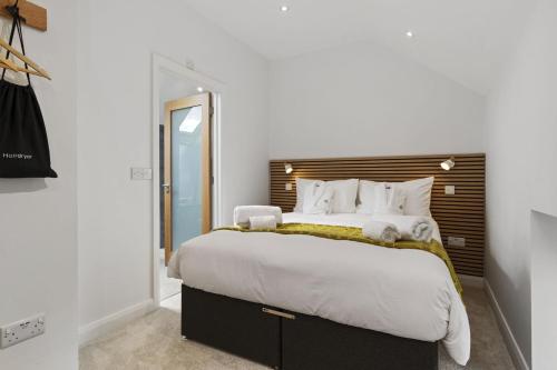 a bedroom with a large bed with white sheets and pillows at The Old School House - A Superb Newly Converted Barn with Hot Tub Sleeping 8 guests in Carmarthen