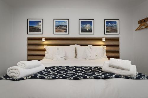 a bedroom with a large bed with towels on it at The Old School House - A Superb Newly Converted Barn with Hot Tub Sleeping 8 guests in Carmarthen