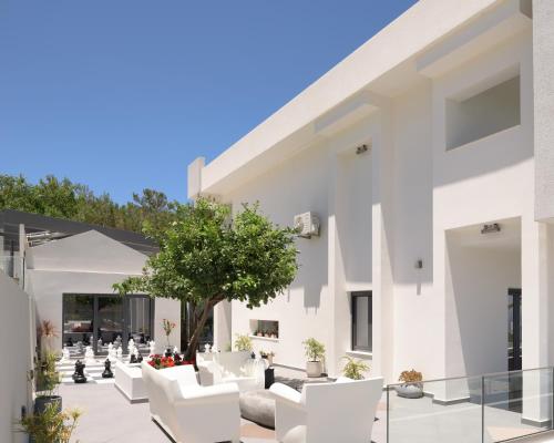 a patio with white furniture and a tree at Villa Kalliston in Rethymno Town
