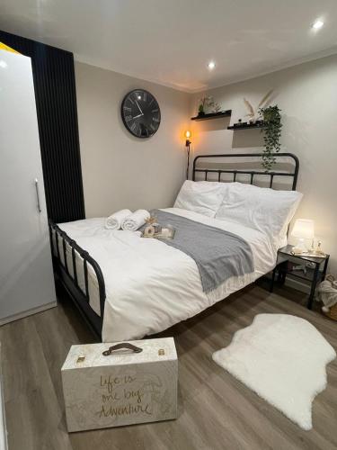 a bedroom with a large bed with a clock on the wall at the manchester signature studio A in Manchester