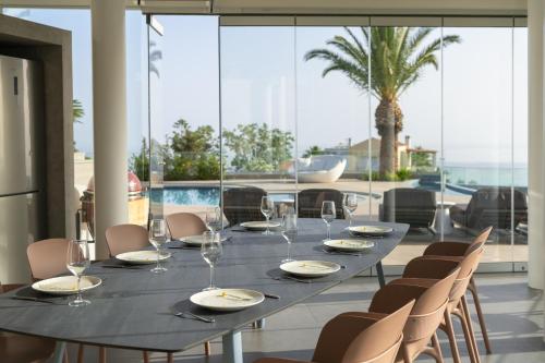 a dining room with a table with glasses and chairs at Villa Kalliston in Rethymno Town