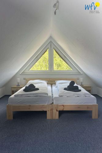 two beds in a room with a window at Huus 24 in Borkum
