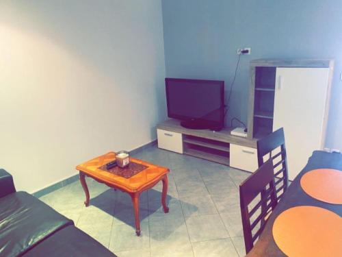 a living room with a table and a tv at Maison de charme Saint euphémie 2 in Sainte-Euphémie