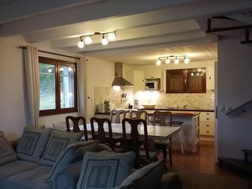 un salon avec une table et une cuisine dans l'établissement maison de montagne spacieuse et chaleureuse, à Guchan